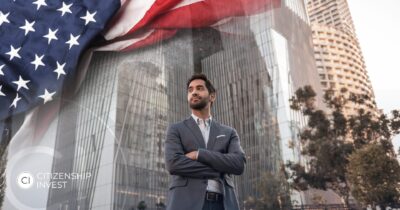 Confident Indian businessman standing in front of U.S. skyscrapers with an American flag, representing EB-5 investor immigration