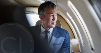 Confident Southeast Asian investor looking out airplane window, symbolizing global investment and mobility